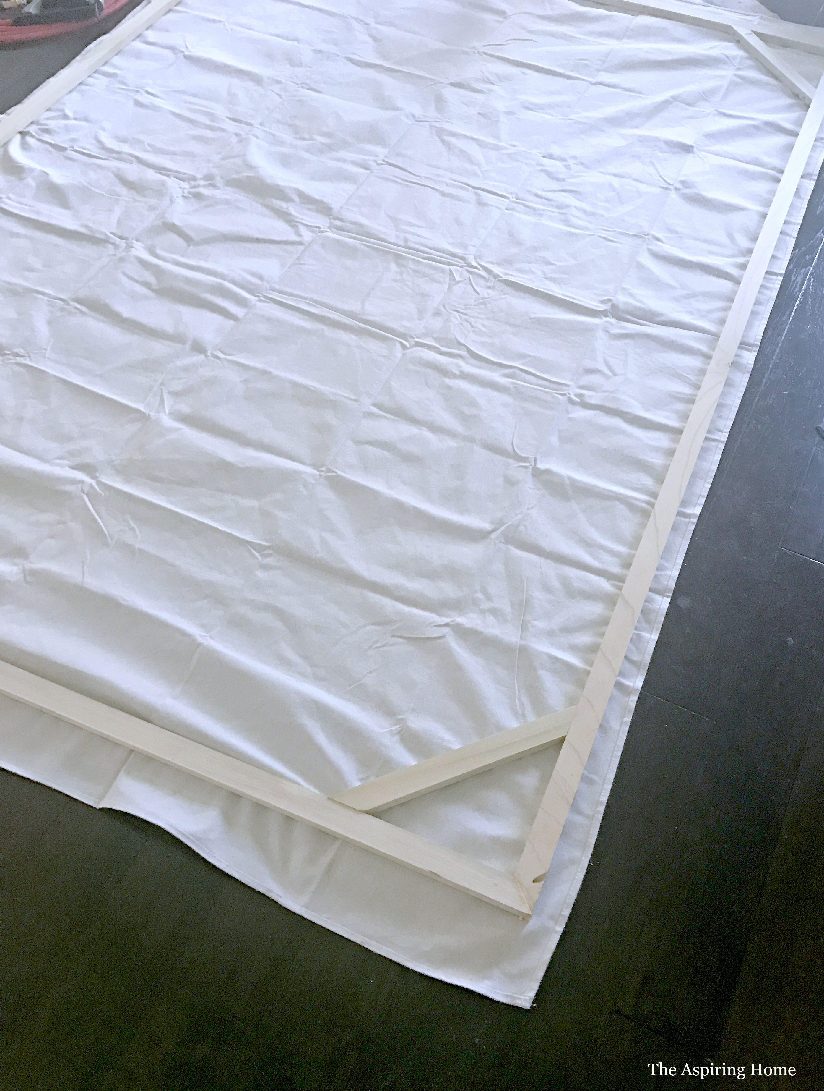 Step 4 elrendezés drop cloth under wood frame to build giant canvas The Aspiring Home