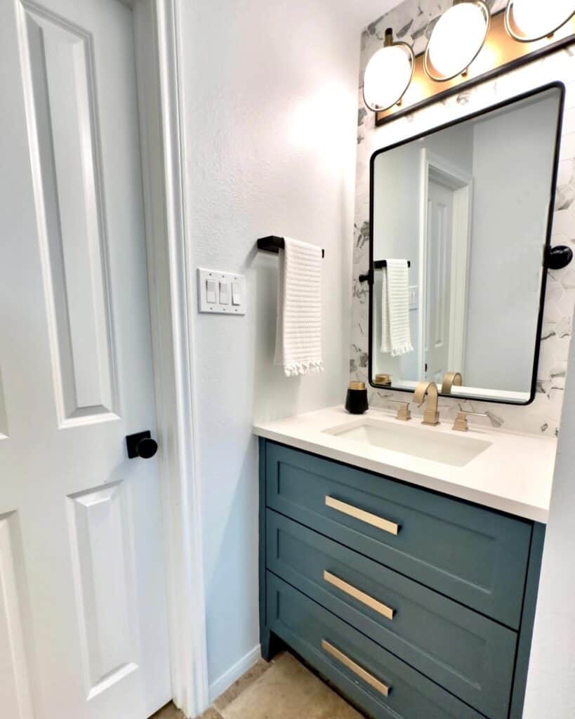 bold vanity color and lighting choice bring personality and warmth to this secondary bathroom. Original floors stayed and the wall tile blended all the color elements beautifully. Expresses the homeowners personality but also created fantastic resale due to bette storage in vanity and livable color palette.